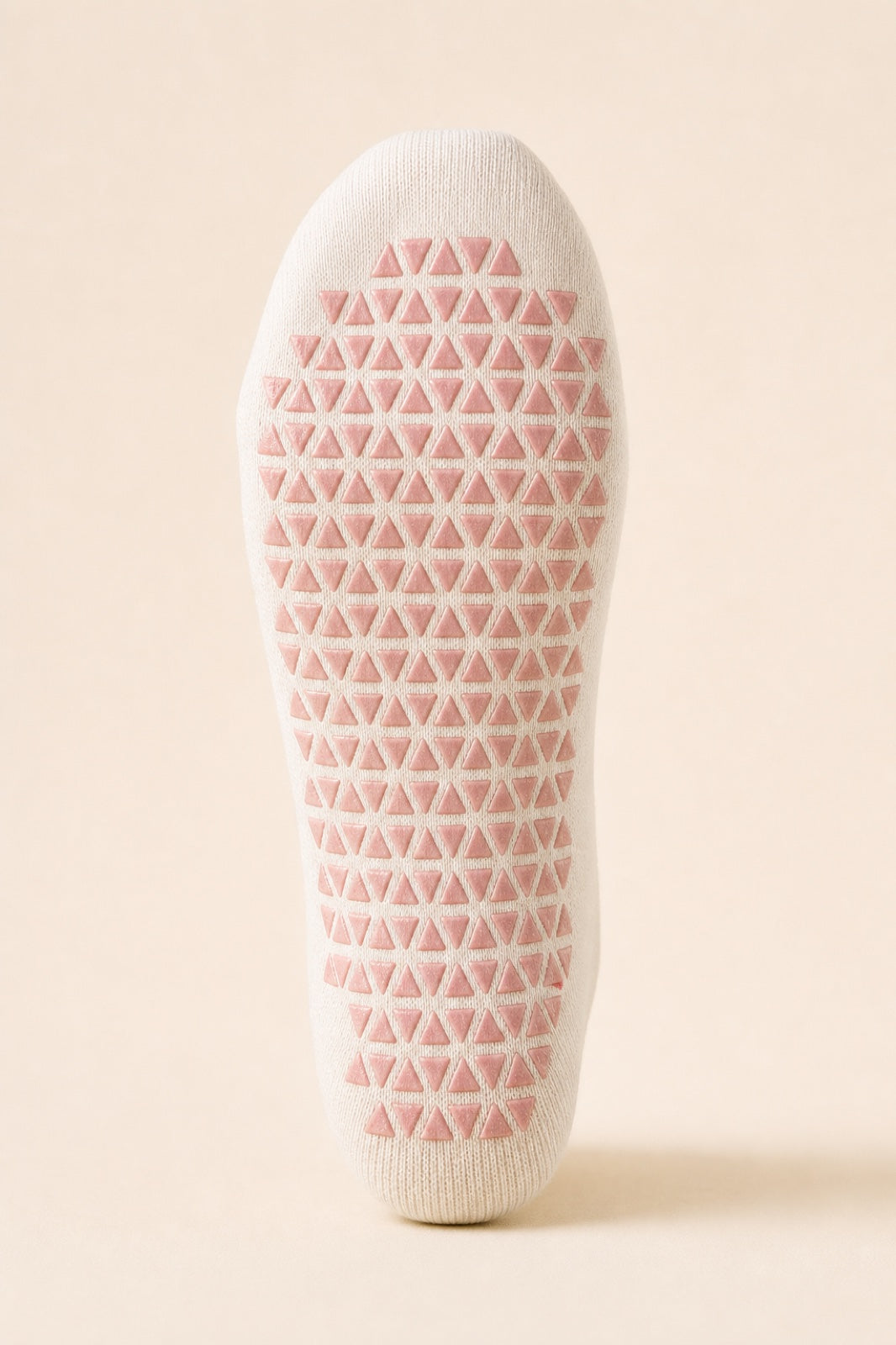 Dense triangular grip covering a cream sock from heel to toe