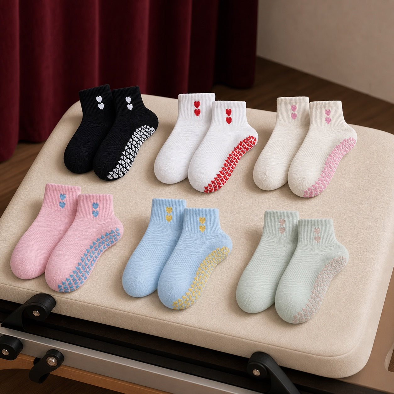 Six VORTRAY grip sock colorways beside a Pilates reformer