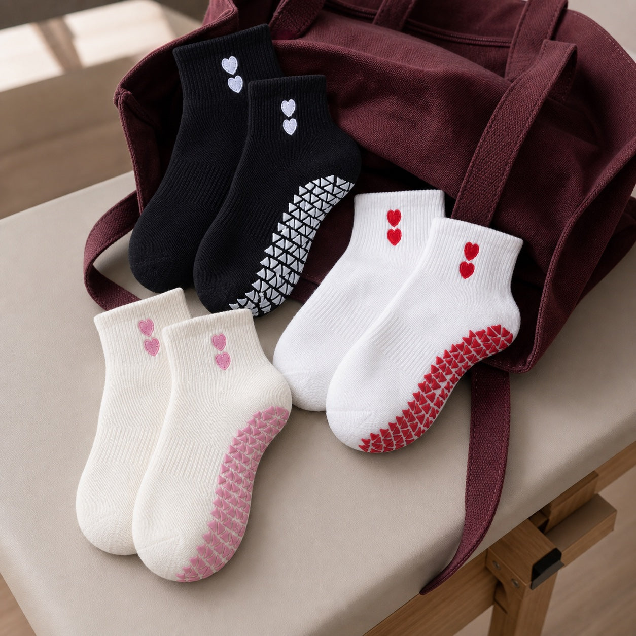 Black, white and cream VORTRAY grip socks arranged beside a studio bag